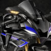 2025 Yamaha YZF-R1M sportbike. Front view with carbon fiber fairings, blue accents, and distinctive headlight design.