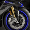2025 Yamaha YZF-R1M front detail. Carbon fiber fairing, blue wheel, gold Ohlins suspension, and Brembo brakes.