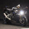 2025 Yamaha YZF-R1M sportbike. Black motorcycle with blue accents, parked on a stand.