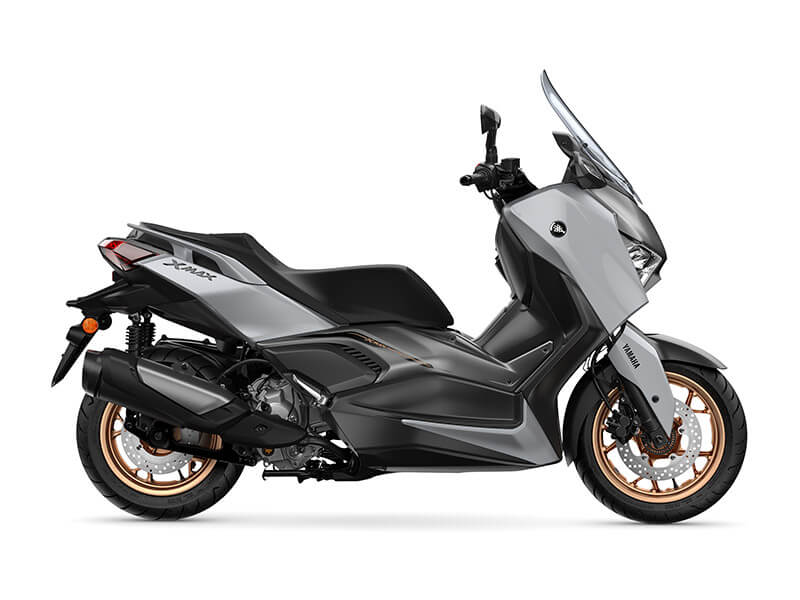 A side view of the YAMAHA XMAX 300 ABS 2024 reveals its sleek gray and black design, highlighted by striking gold rims and a clear windshield, set against a pristine white background.