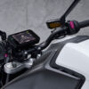 Close-up of the CFMOTO 800NK SPORT handlebar and dashboard, featuring a sleek digital display and controls, with its pristine white fuel tank enhancing the modern allure.