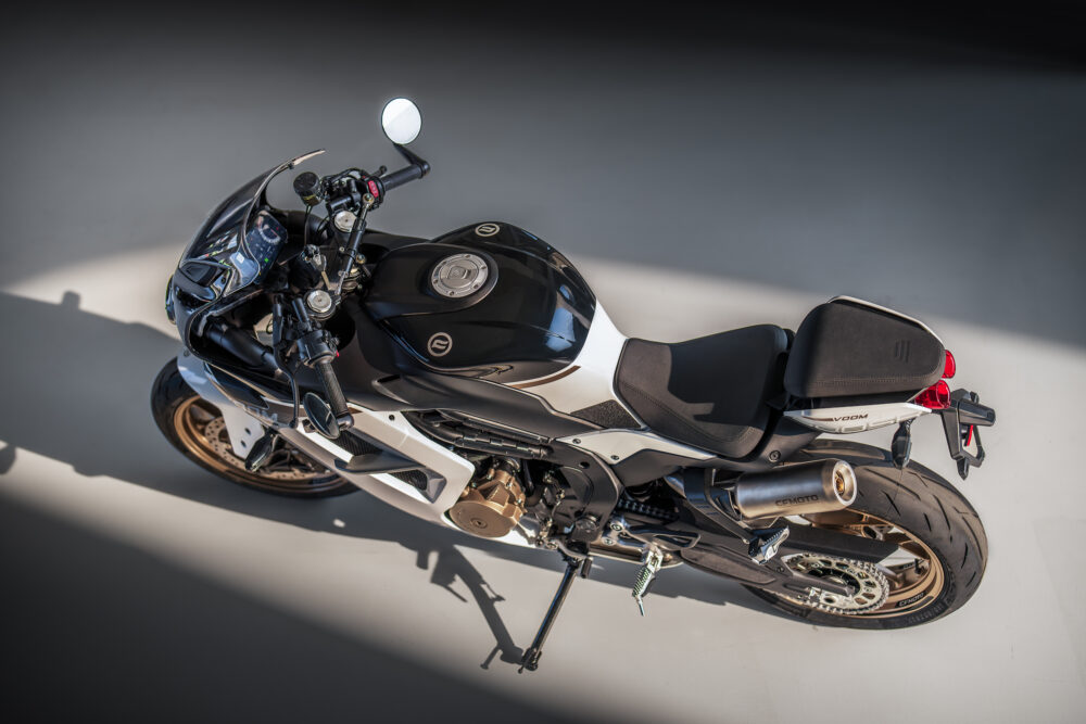 A black and white CFMOTO 500SR VOOM with gold wheels is parked on a smooth, light-colored surface and seen from above at an angle.