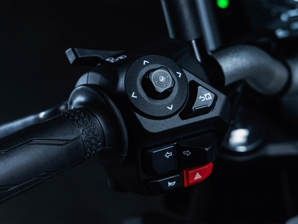 Close-up of the YAMAHA MT-07 HO Y-AMT's motorcycle handlebar control panel, featuring buttons and switches for navigation and operation, along with a textured grip on the handle.