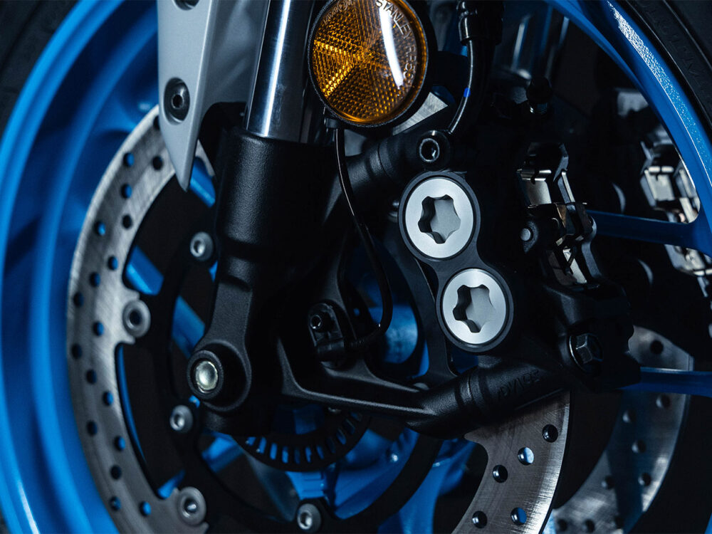 Close-up of the YAMAHA MT-07 HO Y-AMT's front disc brake system with a blue wheel rim, brake caliper, and silver-finished drilled rotor.