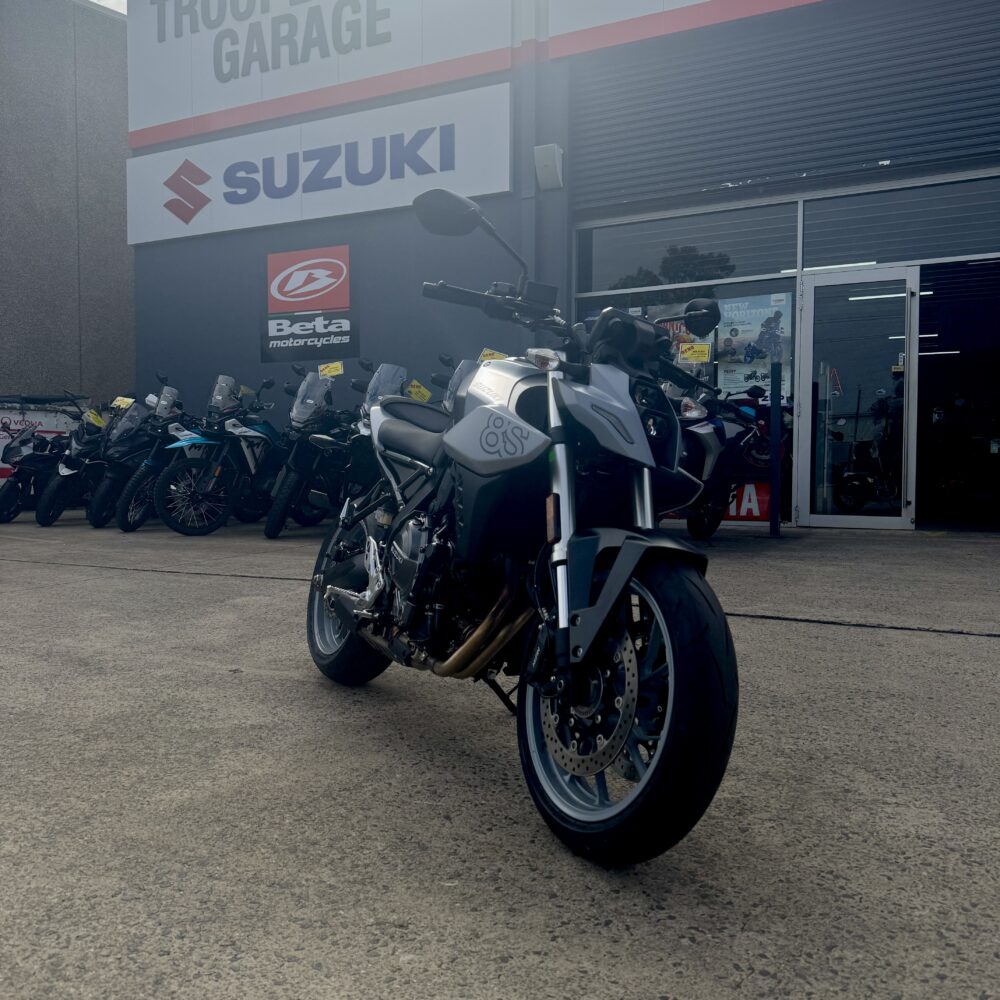 A SUZUKI GSX-8S DEMO is parked outside a dealership, with Suzuki and Beta Motorcycles signs displayed on the building.